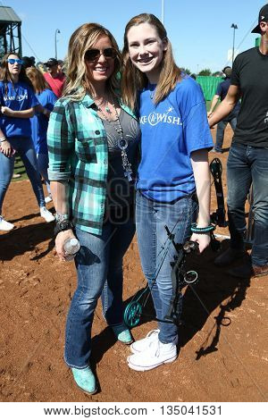 ARLINGTON, TX - APR 18: TV personality Kristy Titus (L) poses with a Make A Wish member at the ACM & Cabela's Great Outdoor Archery Event at the Texas Rangers Youth Ballpark on April 18, 2015.