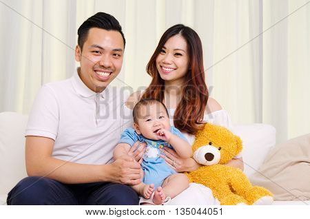 Indooor portrait of beautiful asian family sitting on sofa