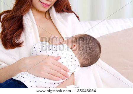 Six months old asian baby boy drinking breastmilk