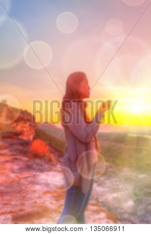 Abstract Blurred and soft photo of Women on hilltop with bokeh of sunrise on the natural background