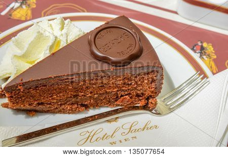 VIENNA AUSTRIA - JUNE 01. 2016: Original Sacher Torte with cream and fork at Sacher Cafe Vienna Austria Europe june 01 2016