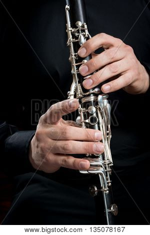 hands of a clarinet player in black