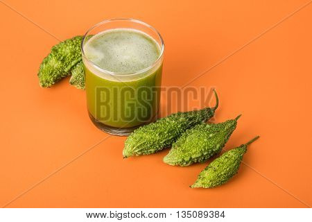 Herbal juice of green momodica in a glass with sliced vegetables, karela juice or bitter gourd juice