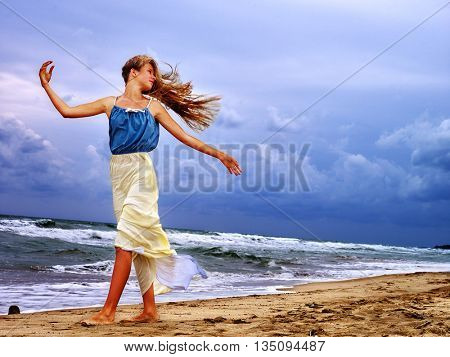 Summer girl sea. Woman on beach near ocean with waves. Wind blew his hair. Girl enjoying bad weather on beach sea.
