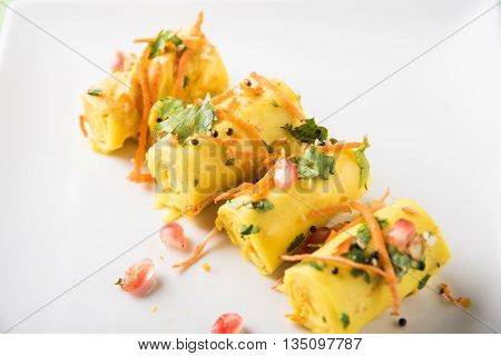 khandvi is a gujarati snack from India which is made with gram flour and curds tempered with sesame seeds and mustard seeds also known as Surali chya Vadya/Stuffed Khandvi, selective focus