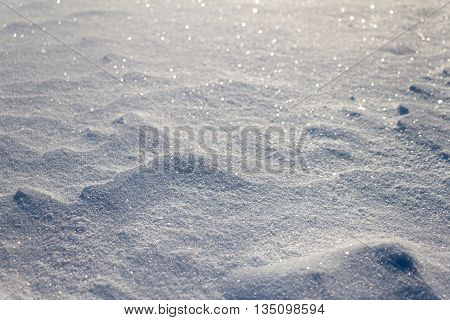 Snow grains close up. Blurred in the distance. Snow cover is not smooth.