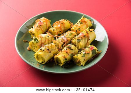 khandvi is a gujarati snack from India which is made with gram flour and curds tempered with sesame seeds and mustard seeds also known as Surali chya Vadya/Stuffed Khandvi, selective focus
