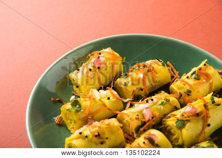 khandvi is a gujarati snack from India which is made with gram flour and curds tempered with sesame seeds and mustard seeds also known as Surali chya Vadya/Stuffed Khandvi, selective focus