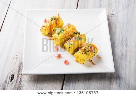 khandvi is a gujarati snack from India which is made with gram flour and curds tempered with sesame seeds and mustard seeds also known as Surali chya Vadya/Stuffed Khandvi, selective focus