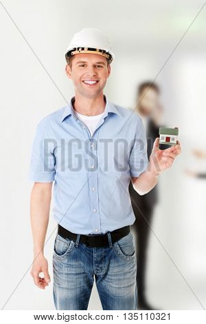 A forewoman holding a model house