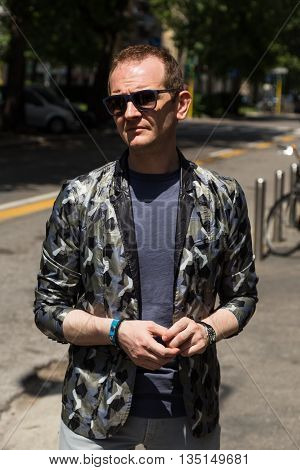 MILAN ITALY - JUNE 18: Fashionable man poses outside Marni fashion show building for Milan Men's Fashion Week on JUNE 18 2016 in Milan.