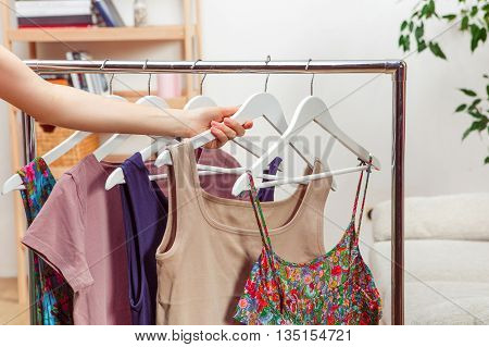 Shopping concept. Woman choosing dresses during shopping or being in wardroom at home.