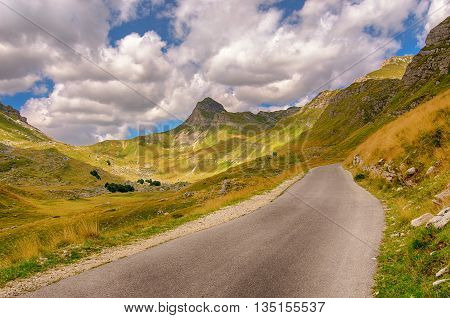 Montenegro national park Durmitor roadmountains and clouds. Daytime sunlight landscape