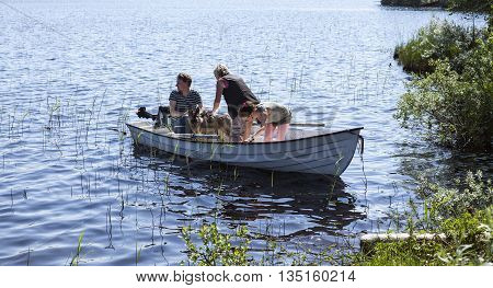 LAPLAND, SWEDEN ON JUNE 06. View of people set out in a small boat on June 06, 2013 in Lapland, Sweden. Warm day, lots of mosquitoes ashore. Unidentified persons. Editorial use.