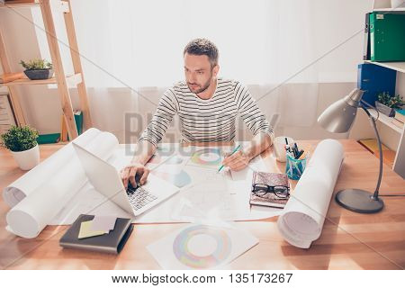 Serious Architect Working With Laptop And Diagramas To Construct New Building