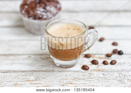 chocolate muffin and cup of coffee on the white wooden background