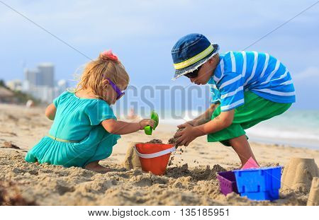 kids play with sand on summer beach, family vacation