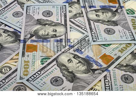 A pile of one hundred dollar bills as background.