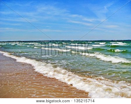 waves of the baltic sea ocean beach in front shore in the background blue sky