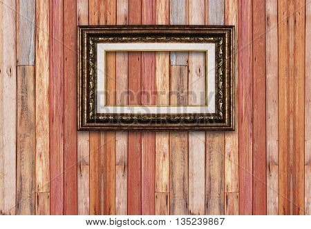 Gold picture frame isolated on wood background.