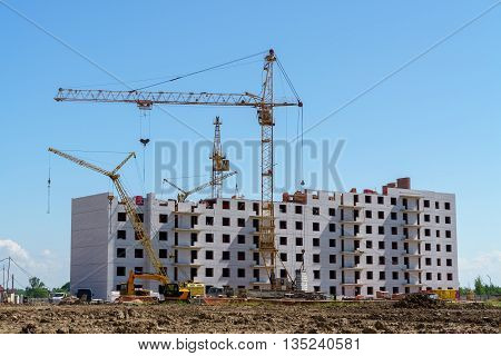 The construction of a multistory building. Construction cranes are on the building site