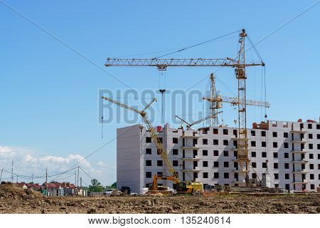 The construction of a multistory building. Construction cranes are on the building site