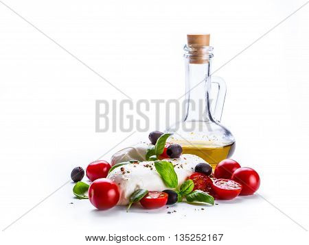 Caprese. Caprese salad. Italian salad. Mediterranean salad. Italian cuisine. Mediterranean cuisine. Tomato mozzarella basil leaves black olives and olive oil over white. Recipe - Ingredients