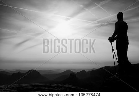 Silhouette Of Tourist With Poles In Hand. Sunny Spring Daybreak