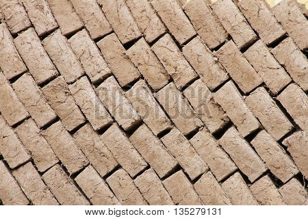 Background of newly dried adobe bricks stacked in a diagonal pattern