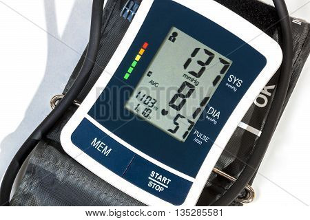 Close up right side view of blood pressure monitor cuff and pipe on over white