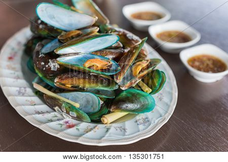 Thai Food steamed mussels with basil and lemongrass. Eaten with spicy sauce.