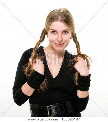 Blonde smiling girl holding her curled hair with both hands. Studio, white background.