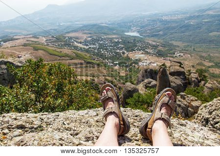 Men in sport sandals lies on the top of Demerdzhi mountain. Close up detail of male feet. Relax after climbing. Crimea Russia.
