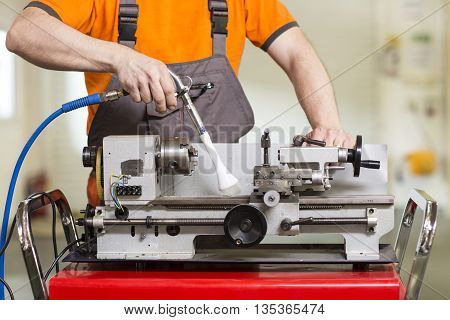 Machinist working a metal lathe in workroom
