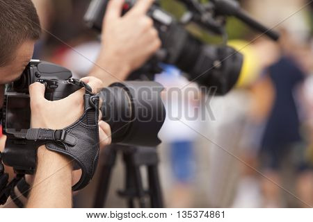 Photoreporter Covering A Media Event With His Photo Camera. Journalist Taking Photos With Photo Came