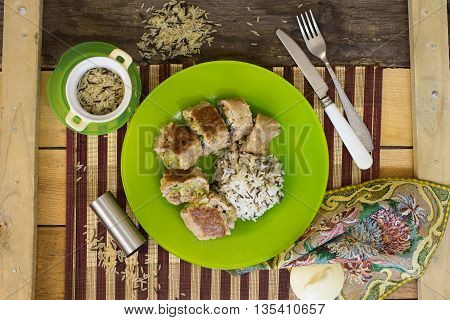 Veal Saltimbocca with Sage on green plate on wooden table