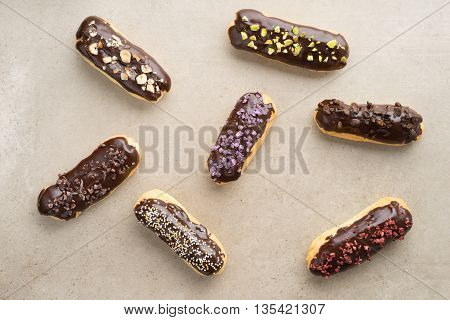 Eclairs with chocolate ganache with different toppings