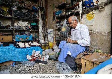 SHIRAZ - APRIL 14: Unknown man repairs shoes in a market (Vakil Bazaar) in Shiraz Iran on April 14 2015. Vakil Bazaar is the most important tourist attraction in Shiraz Iran.