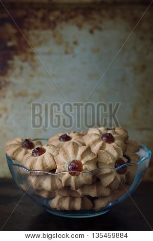Glass bowl full of biscuit cookies with jam