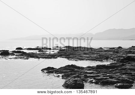Rocks on the coast of Cretan Sea near Hersonissos Crete Greece. Black and white.