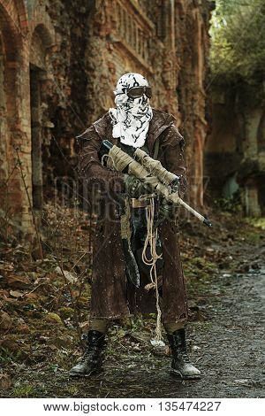 Nuclear post-apocalypse. Sole survivor in tatters and gas mask on the ruins of the destroyed city