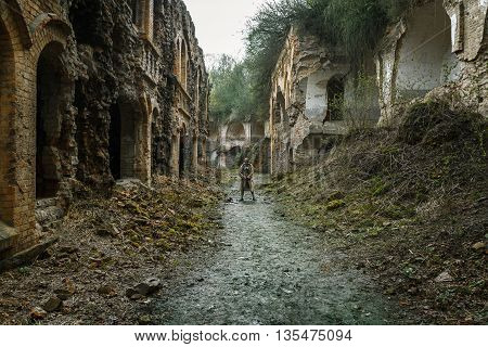 Nuclear post-apocalypse. Sole survivor in tatters and gas mask on the ruins of the destroyed city