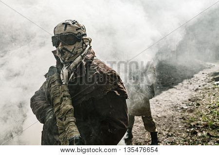 Nuclear post-apocalypse. Survivors in tatters and gas mask on the ruins of the destroyed city