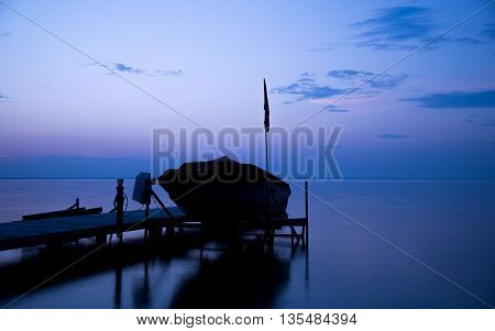 Docked boat a the cottage at dusk
