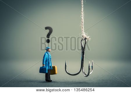 Miniature businessman is staring at fishing needle