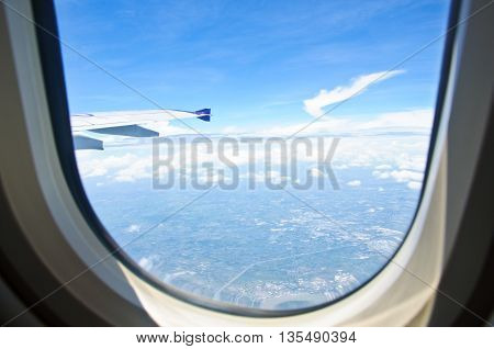 View from the airplane seat -- window with sky clouds