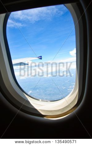 Clouds and sky as seen through window of an aircraft