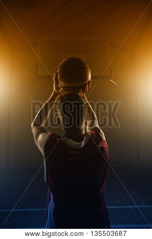 Portrait of basketball player front the back preparing to score on a gym