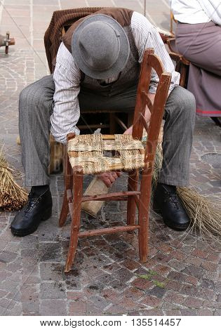Artisan Mender Of Chairs With Straw Shelters An Old Wooden Chair