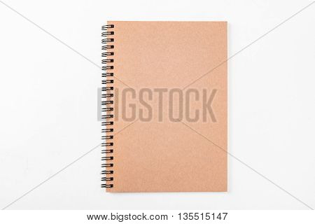 blank brown spiral paper notebook front cover brown paper isolated on white background.